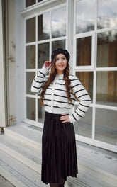 A lady wears a striped cardigan.